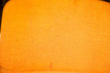 Vintage Pirelli Castelli chair's textured orange fabric upholstery, showing minor condition issues.