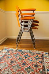 Stacked Pirelli by Castelli DSC chairs, showing aluminum frames and orange fabric.