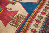 Geometric red and plum Caucasian style motifs with blue, yellow, and green borders.
