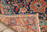 Vintage blue Heriz rug corner, showing saturated red border, mint details, and fringe.