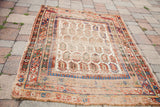 Distressed texture and geometric border motifs with boteh pattern on antique Caucasian rug.