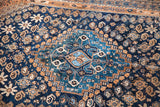 Teal blue medallion and earthy geometric motifs on an antique Southwest Persian tribal rug.