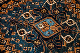 Stepped geometric medallion detail in rich teal, rust, and cream on a Southwest Persian rug.