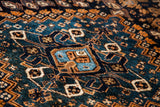 Intricate hand-knotted tribal pattern detail in vibrant teal and deep earth tones.