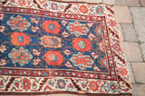 Detail of a late 19th century Persian runner: deep blue field, coral veramin motifs, worn ivory border.