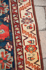 Detailed view of antique Persian runner's Veramin floral motif in blue, red, and cream border.