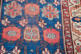 Antique Persian runner with deep blue field and vibrant red, light blue, beige floral veramin motifs.