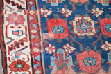 Antique Persian runner detail: blue field with floral veramin motif, cream border, and patina of age.