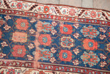 Close-up of antique Persian runner's veramin floral motif with aged blue pile.