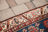 Cream border, aubergine and blue floral veramin motifs on an antique Persian runner.