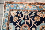 Faded indigo blue Lilihan rug corner, featuring intricate peach and beige floral veramin motifs.