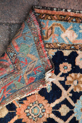 Hand-knotted foundation and indigo-peach floral pattern of the Lilihan rug.