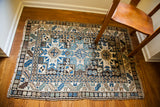 Detailed geometric Lesghi tribal pattern in blue and ivory on a vintage Caucasian rug.