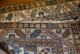 Vintage Caucasian Kazak rug with Lesghi geometric patterns and raw fringed end.