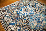 Vintage Caucasian rug showcasing intricate blue, beige, and brown Lesghi star motifs.