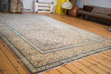 Distressed ivory field and blue-rust floral border of a vintage Tabriz rug.