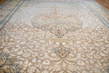 Vintage Tabriz rug's distressed ivory floral field with soft rust and blue accents.