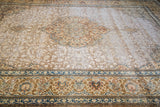 Distressed Tabriz rug: subtle field patterns and ornate border in rust, blue, ivory.