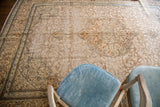 Vintage Tabriz rug showing distressed floral patterns in silver, ivory, rust, and blue tones.
