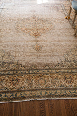 Distressed vintage Tabriz rug with faded field and ivory, rust, blue floral border.