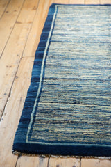 Deep blue border frames the unique striated indigo field of this antique Chinese rug.