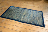 Antique Chinese Peking Rug corner with deep indigo border and striated 'running water' motif.