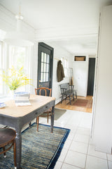 The antique Chinese Peking rug's unusual striated indigo motif under a rustic table.