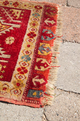 Hand-knotted fringe and red, gold, blue geometric border of the vintage Turkish rug.