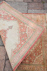 Folded corner of a late 19th-century silk Tabriz rug showing its detailed pile and fine weave.
