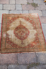 Antique silk Persian Tabriz rug with a central rust medallion on an open ivory field.