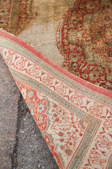 A folded corner of the antique silk Tabriz reveals its fine, hand-knotted foundation and weave.