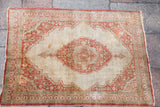 Complete view of a fine antique silk Tabriz rug, detailing its rust and green medallion on an ivory field.