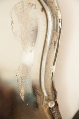 Distressed beveled glass edge and mottled silvering of an Art Deco mirror.