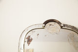 Distressed beveled glass, curved edge, and top rhinestone detail of an Art Deco mirror.