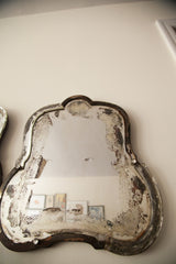 Close-up of the weathered, distressed glass and beveled edge of an Art Deco mirror.