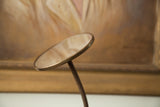 Mid century bathroom gooseneck mirror with round metallic head and coiled stem.