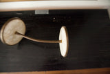 Mid Century gooseneck mirror's flexible stem and round, light-toned head.