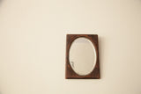 Rectangular wood mirror frame with rich aged patina and oval beveled glass.