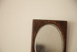 Detail of dark wood frame with visible grain, aged patina, and beveled glass.