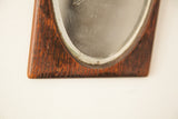 Textured wood frame displaying aged patina and beveled glass edge.