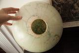 Hand holding light blue vintage Repologie globe, detailed top with open lamp hole.