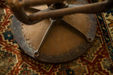 Underside of Victorian antique industrial stool, showing aged wood and metal construction.