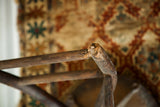 Detail of the industrial Victorian stool's wooden leg with visible age and broken joint.