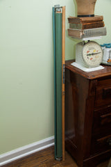 Vintage Frohse pulldown chart rolled up, showing its green back and original hardware.