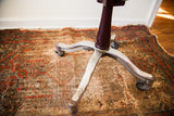 Art Deco curved metal base, brownish central pole, and original steel castors.