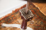 Rusted metal adjustment mechanism of the antique Shuron Genothalmic stool.