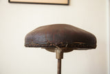 Cracking dark brown leather seat edge with original nail-back trim.