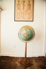 Vintage Repologie globe with blue oceans, colorful landmasses, and wooden stand detail.