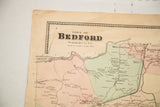 Upper left corner of antique Bedford map, with title, light colors, and edge holes.