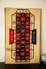 Vintage folk art roulette gaming board with hand-painted red and black numbers on wood.